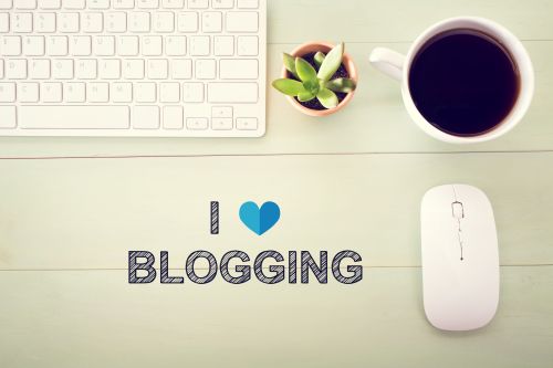 I Love Blogging concept with workstation on a light green wooden desk