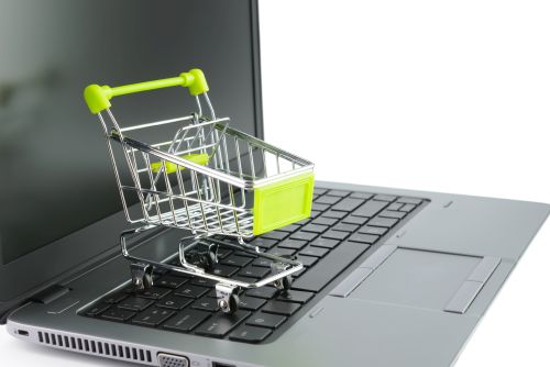 Concept of online shopping with miniature shopping cart on keyboard